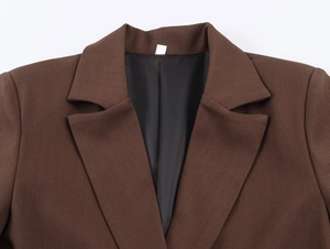 Nahaufnahme des Reverskragens und der braunen Stoffstruktur eines lockeren Blazers
