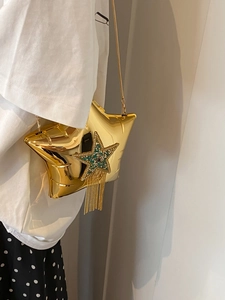 Detail of star-shaped bag with gold fringe tassels and green beaded center decoration