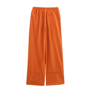 Detail view of orange wide-leg linen pants with elastic waist and back pocket design
