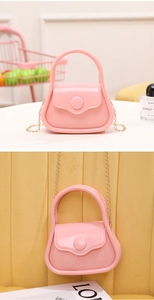 Pink mini jelly bag detail featuring a golden chain strap and round snap closure design