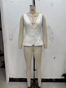 Detailed view of a white V-neck vest featuring a five-button closure and a flared hemline