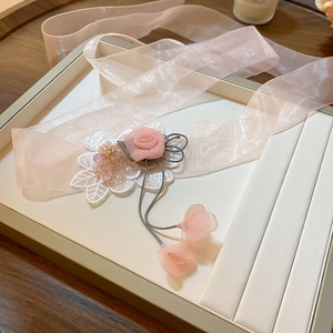 Detailed shot of pink fabric rose and organza ribbons in a jewelry display box