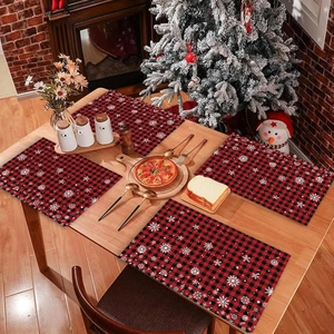 Christmas place mats set with red and black plaid snowflake patterns on wooden table