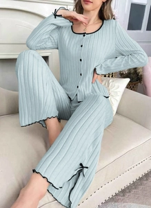 Detail of light blue ribbed pajama set with black wavy edges and delicate bow accents