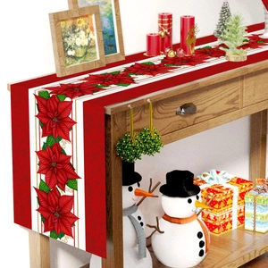 Christmas table runner with red poinsettia floral patterns on wooden holiday table decor