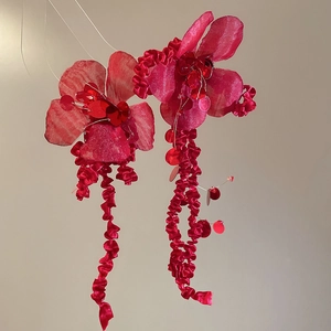 Detail of red fabric flower earrings with crystal sequins and long tassel fringe