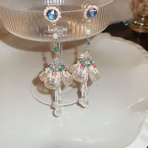 Detail of long tassel earrings with purple gems, pearls, and intricate beadwork