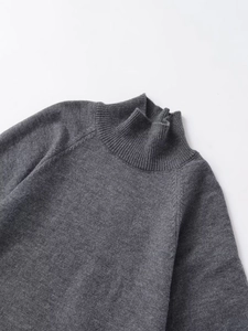 Close-up of dark grey turtleneck sweater featuring ribbed collar and fine knit texture