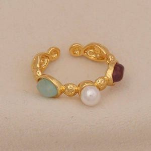 Macro detail of gold vintage ring with turquoise, pearl and purple gemstone beads