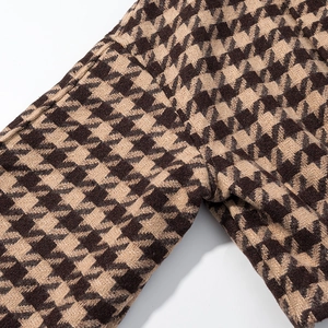 Macro view of brown and beige houndstooth tweed texture and seamless stitching detail