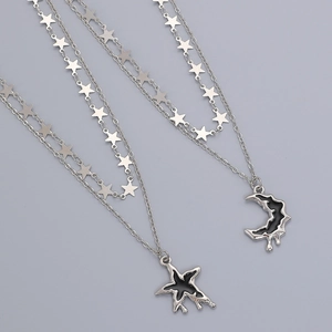 Detail of silver liquid lava moon and star pendant necklaces with black enamel finish