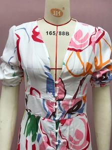 Close-up of deep V-neckline and white button details on floral print summer dress