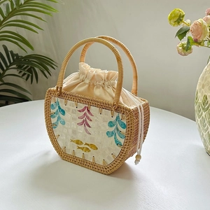 Detail of handmade rattan bag featuring exquisite shell inlay with fish and floral motifs