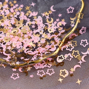 Macro shot of pink and gold star and moon nail art sequins for DIY resin crafts