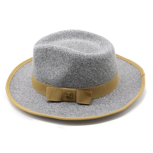 Close-up of gray wool fedora hat featuring khaki ribbon bow and golden metal buckle