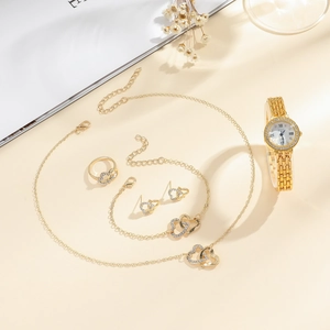 Close-up of gold heart jewelry set including necklace, bracelet and XSVO quartz watch