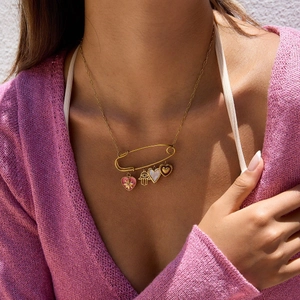 Gold paperclip chain necklace with heart charms and Hamsa hand on a female model