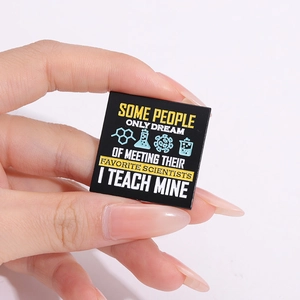 Broche carrée en émail noir pour enseignant avec texte jaune et icônes scientifiques bleues