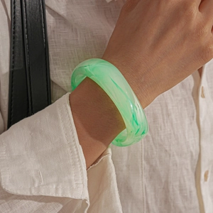 Detail of green marble resin bangle showing smooth texture and high gloss finish