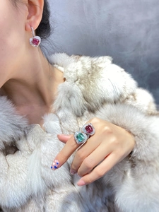 Nahaufnahme einer luxuriösen Herz-Turmalin-Ring- und Ohrring-Kombination mit Diamanten.