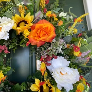 Colorful summer wreath with eucalyptus, orange roses, sunflowers, and peonies for door decor