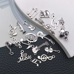 Flat lay of antique silver musical instrument charms including guitar and violin