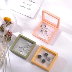 Close-up of pink, green and yellow jewelry suspension boxes with transparent PE film