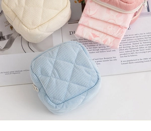 Detail of quilted corduroy sanitary napkin pouches in light blue, pink and beige tones