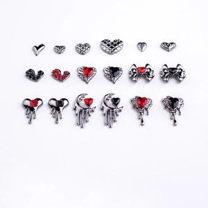 Macro view of gothic metal nail art charms with heart, moon and red rhinestones