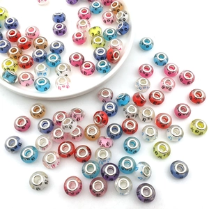 Macro shot of colorful glass large hole beads with paw prints and metal cores for DIY bracelets