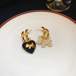 Asymmetric gold plated dog and heart stud earrings with sparkling cubic zirconia stones