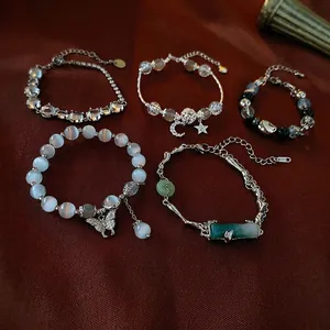 Cat eye stone butterfly and moon star charm bracelets set on a luxury fabric