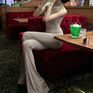Detail of beige sleeveless turtleneck top and high-waisted flared trousers set for women