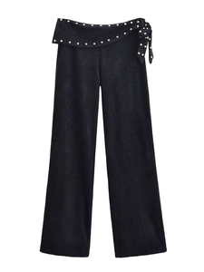 Detail of high-waist black flare pants with silver rivets and side lace-up design