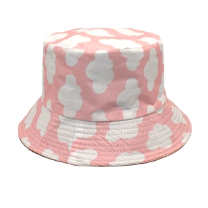 Detailed view of pink bucket hat with white cloud patterns on smooth cotton fabric