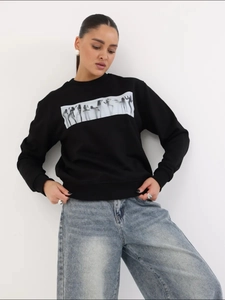 Λεπτομέρεια από μαύρο oversized φούτερ με καλλιτεχνικό ορθογώνιο τύπωμα πορτρέτου