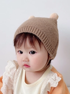 Cute brown knitted baby hat with bear ears and ear protection for winter warmth