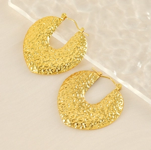 Détail de boucles d'oreilles en acier plaqué or 18K avec finition à texture martelée