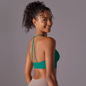 Detail of dark green yoga bra with thin criss-cross back straps on female model