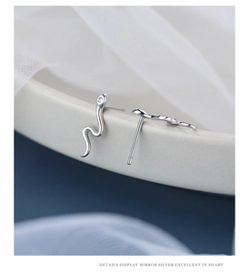 Macro shot of silver snake stud earring with white zircon inlay on s925 sterling silver