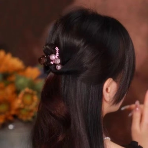 Detail of elegant small hair claw clip with purple pearls and rhinestones on hair