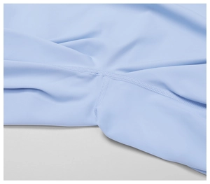 Detailed macro view of flatlock reinforced seams on light blue yoga shorts fabric