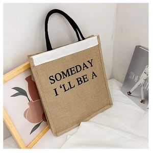 Detail view of linen tote bag with black rope handles and minimalist printed text slogan