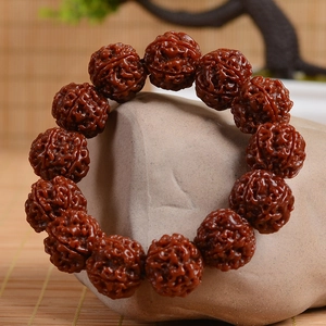 Rudraksha bodhi seed bracelet with 14 carved brown beads on a Zen stone display