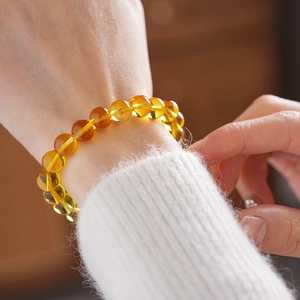 Macro detail of amber bead bracelet showing natural yellow textures and polished finish