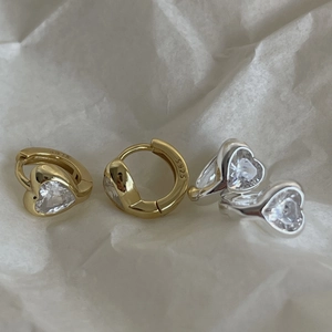 Macro detail of S925 sterling silver heart earrings in gold and silver with cubic zirconia