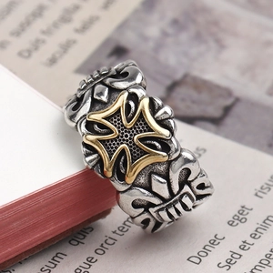 Macro shot of vintage silver ring with golden cross on open book pages