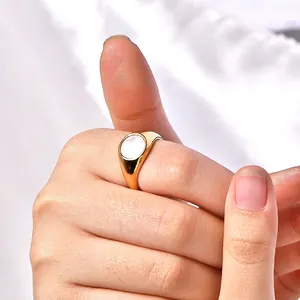 Minimalist gold-plated geometric ring with a white shell inlay worn on a model finger