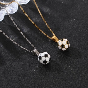 Soccer ball pendant necklace in gold and silver finish on a black textured background