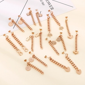 Rose gold stainless steel Cuban chain earrings with diverse stylish pendants on cream base